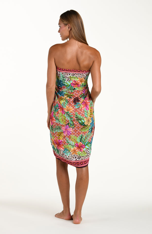 Full body back image of model wearing a multicolored tropical and leopard printed pareo wrap featuring a tie side. This is paired with a matching bikini top.