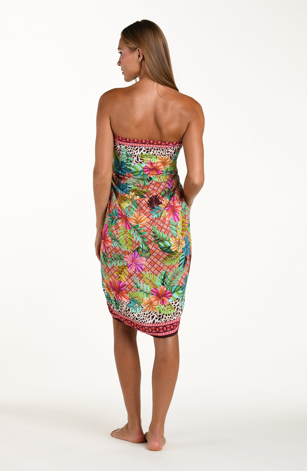 Full body back image of model wearing a multicolored tropical and leopard printed pareo wrap featuring a tie side. This is paired with a matching bikini top.
