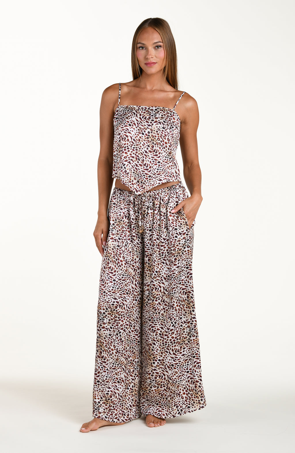 Full body front image of model wearing a leopard printed cover up top featuring over the shoulder adjustable straps and a scarf hem. This is paired with matching pants. 