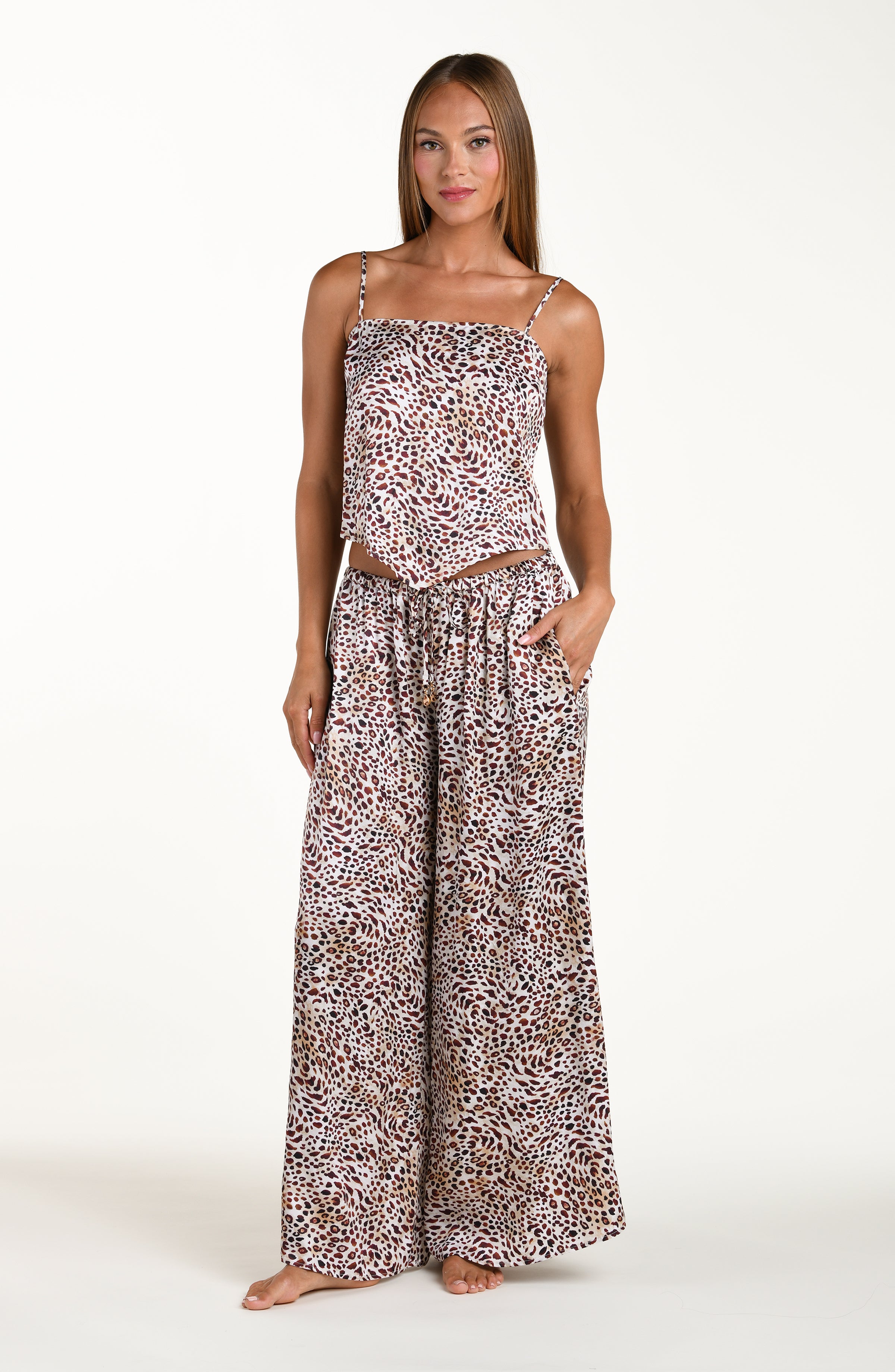 Full body front image of model wearing leopard printed beach pants with an elastic waist and pockets. This is paired with a matching midkini top. 