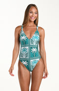 Woman wearing a tropical patterned one-piece swimsuit on a white background