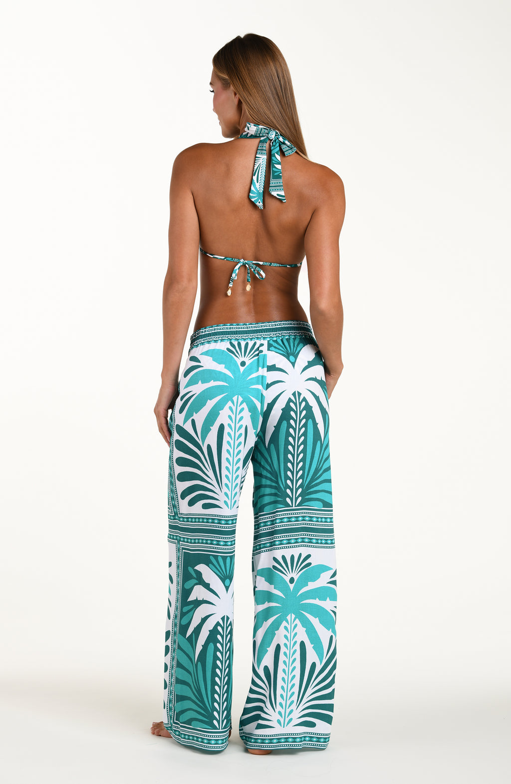 Woman wearing a turquoise and white patterned outfit on a white background
