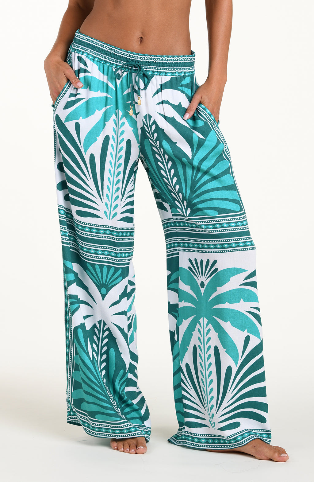 Tropical patterned pants worn by a person on a white background