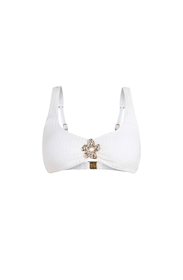 Ivory colored bikini top with a decorative clasp on a white background