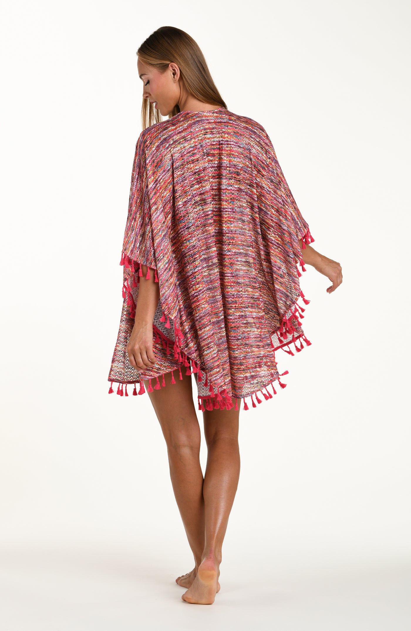 
                  
                    Full body back image of model wearing an open front kimono cover up with three quarter sleeves and tassel trim featuring a multicolored ripple print.
                  
                