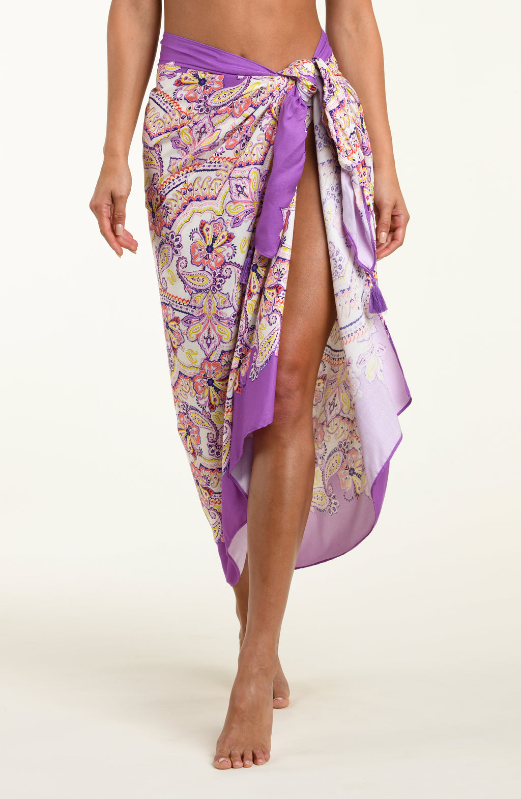 Person wearing a multicolored purple pareo wrap against a white background