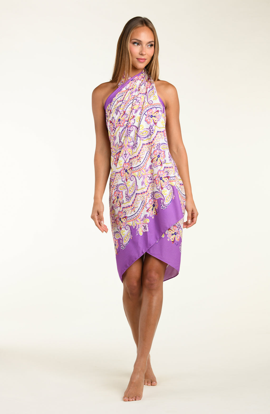 Person wearing a multicolored purple  pareo wrap against a white background