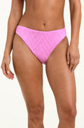 Pink bikini bottom worn by a person on a white background