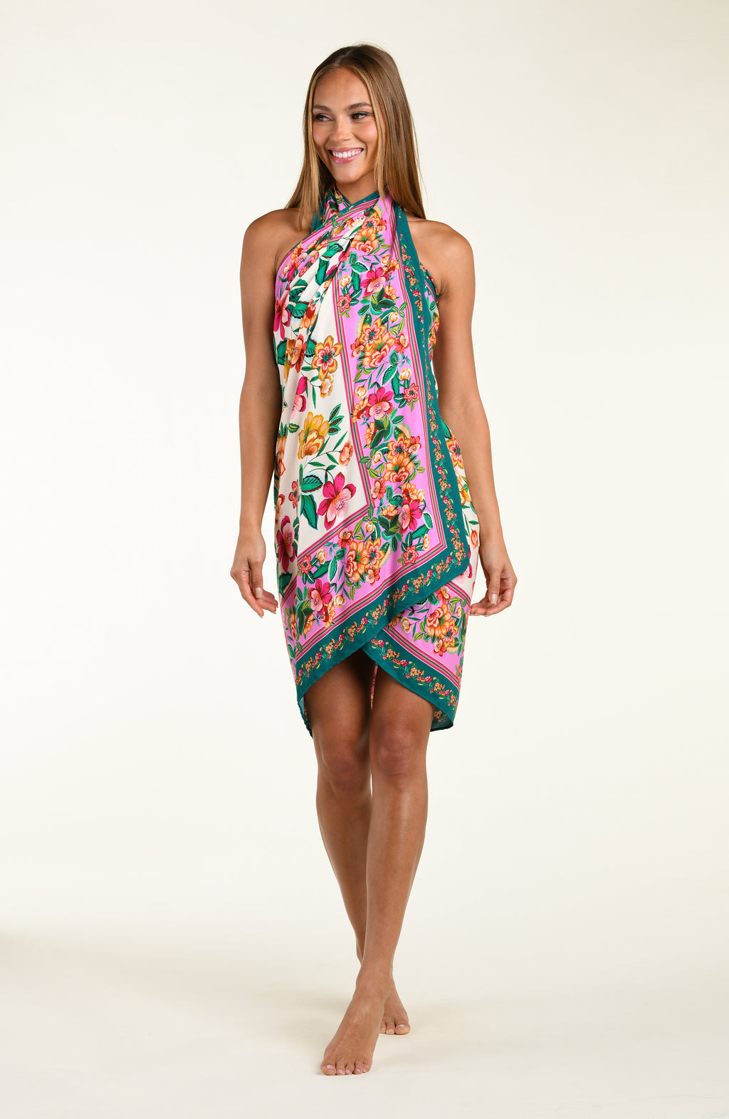 Woman wearing a floral patterned  pareo cover up worn by a person on a white background