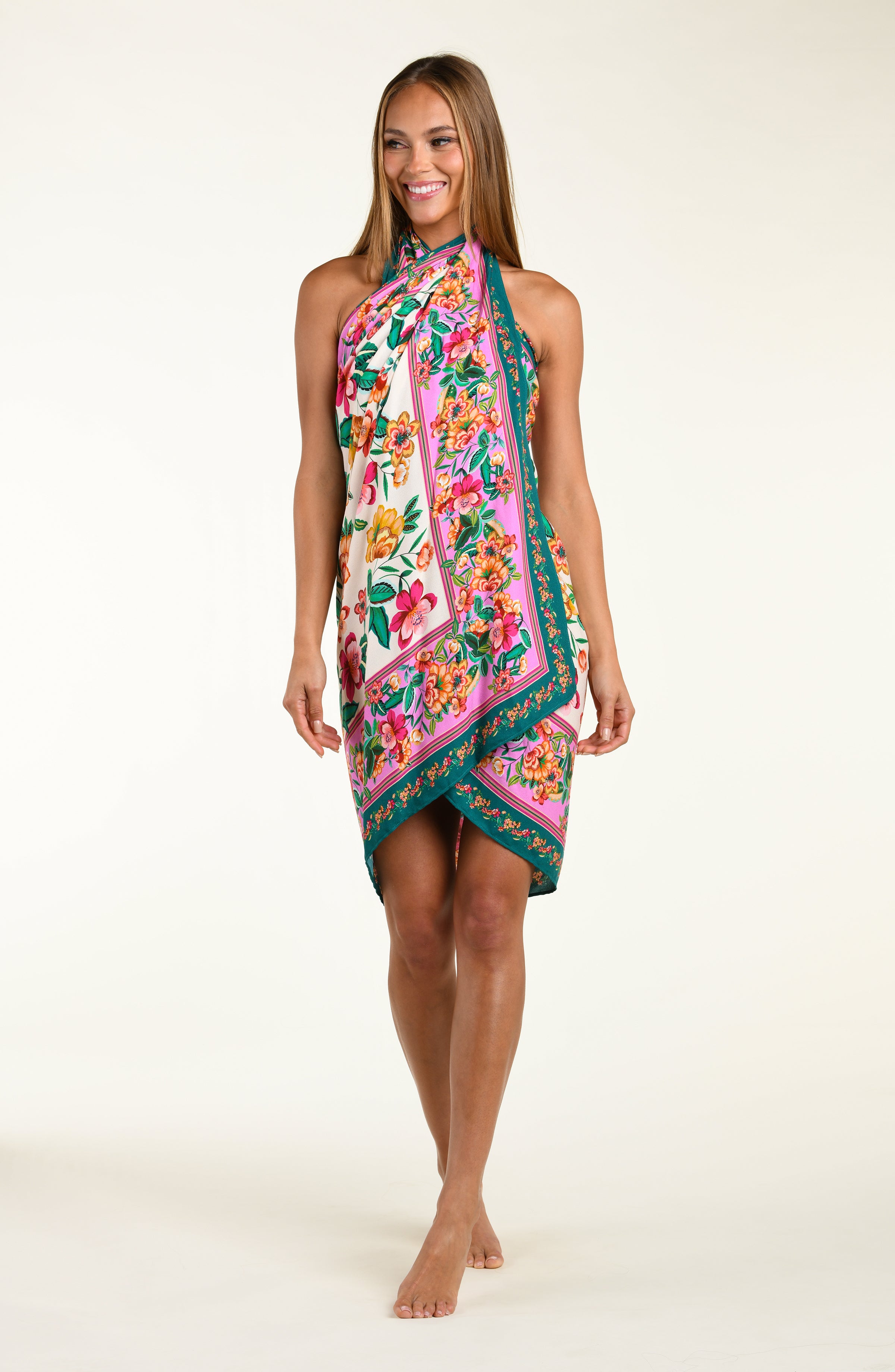 Woman wearing a floral patterned  pareo cover up worn by a person on a white background