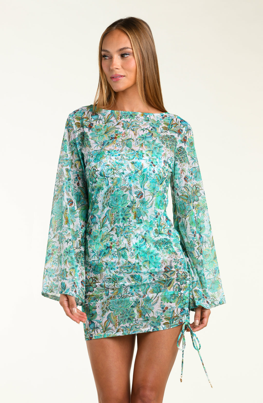 Woman wearing a turquoise floral tunic cover up with bell sleeves on a white background