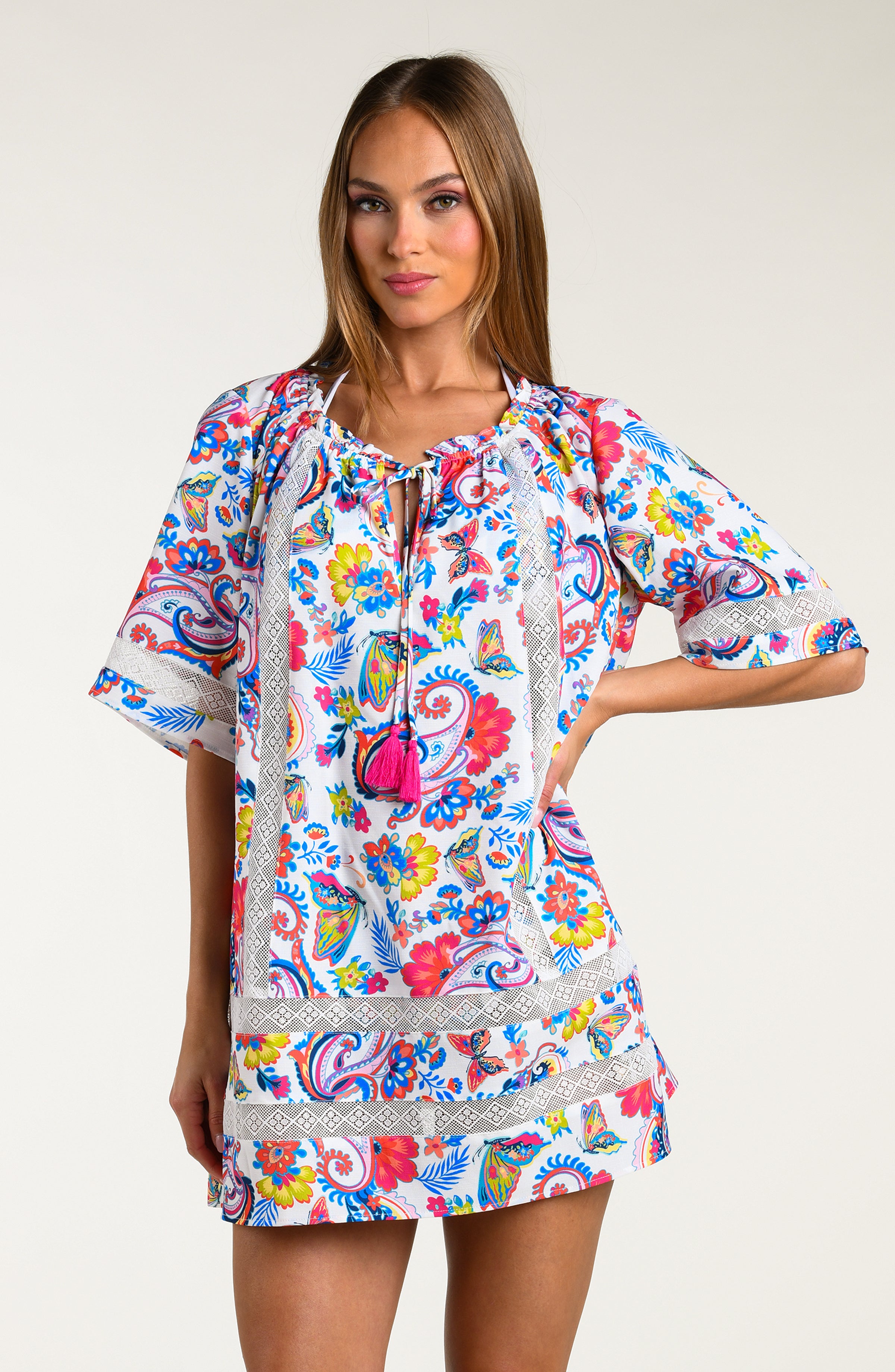 Woman wearing a multicolored tunic cover up against a white background.
