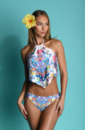Woman wearing a colorful floral midkini top and matching bottom against a blue background