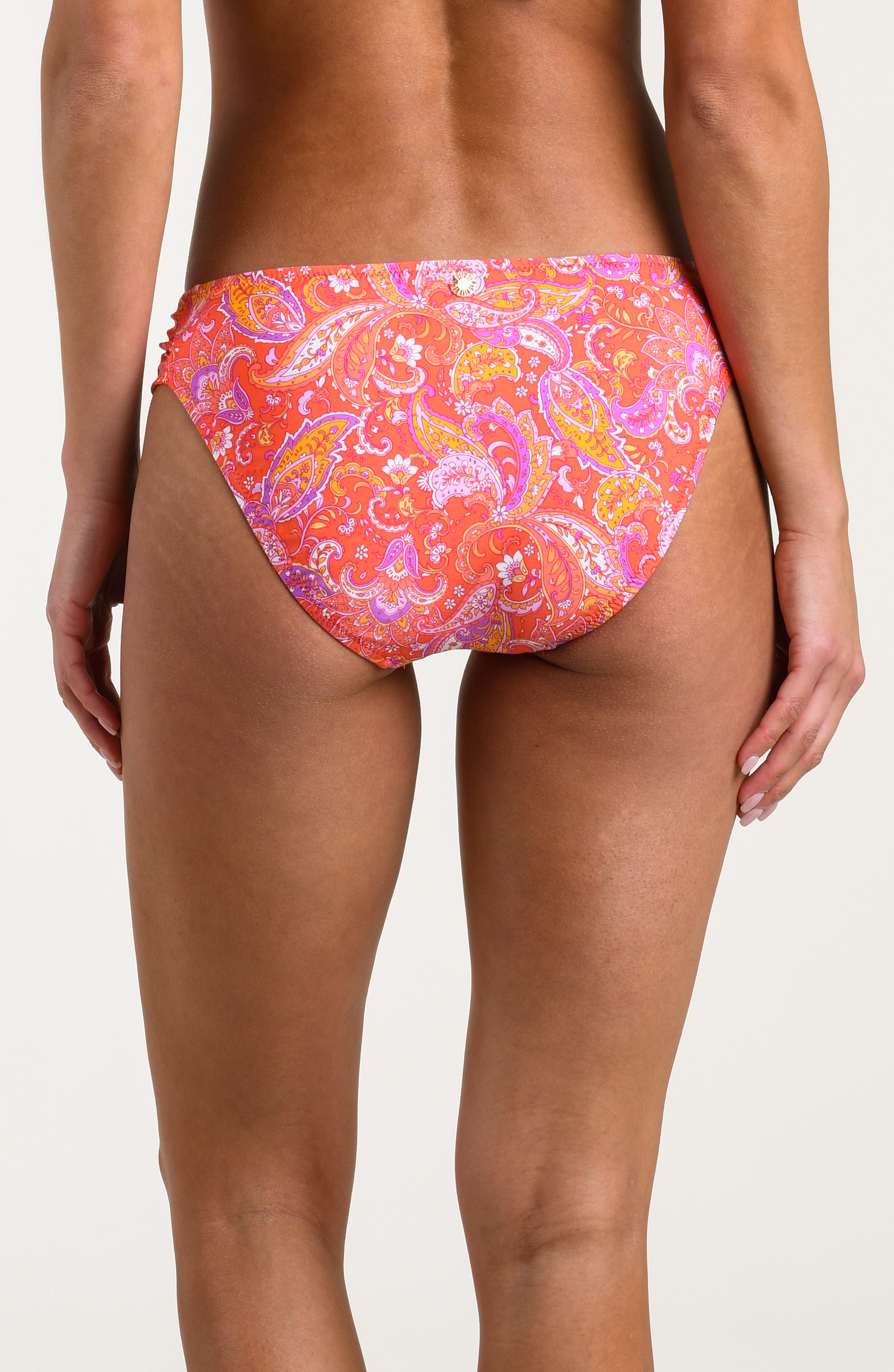 Person wearing a pink and orange multicolored bikini bottom on a white background