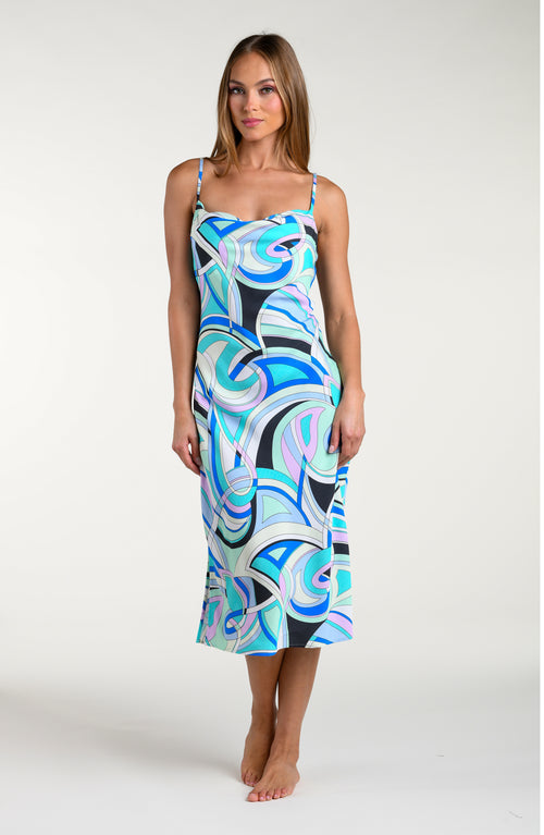 Woman wearing a multicolored patterned midi dress against a white background