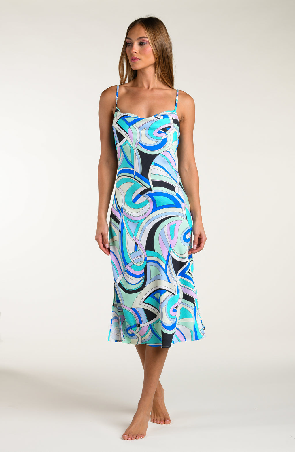 Woman wearing a multicolored patterned midi dress against a white background