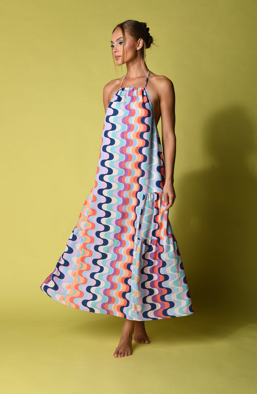Woman wearing a multicolored maxi dress against a yellow background