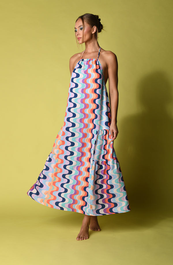 Woman wearing a multicolored maxi dress against a yellow background