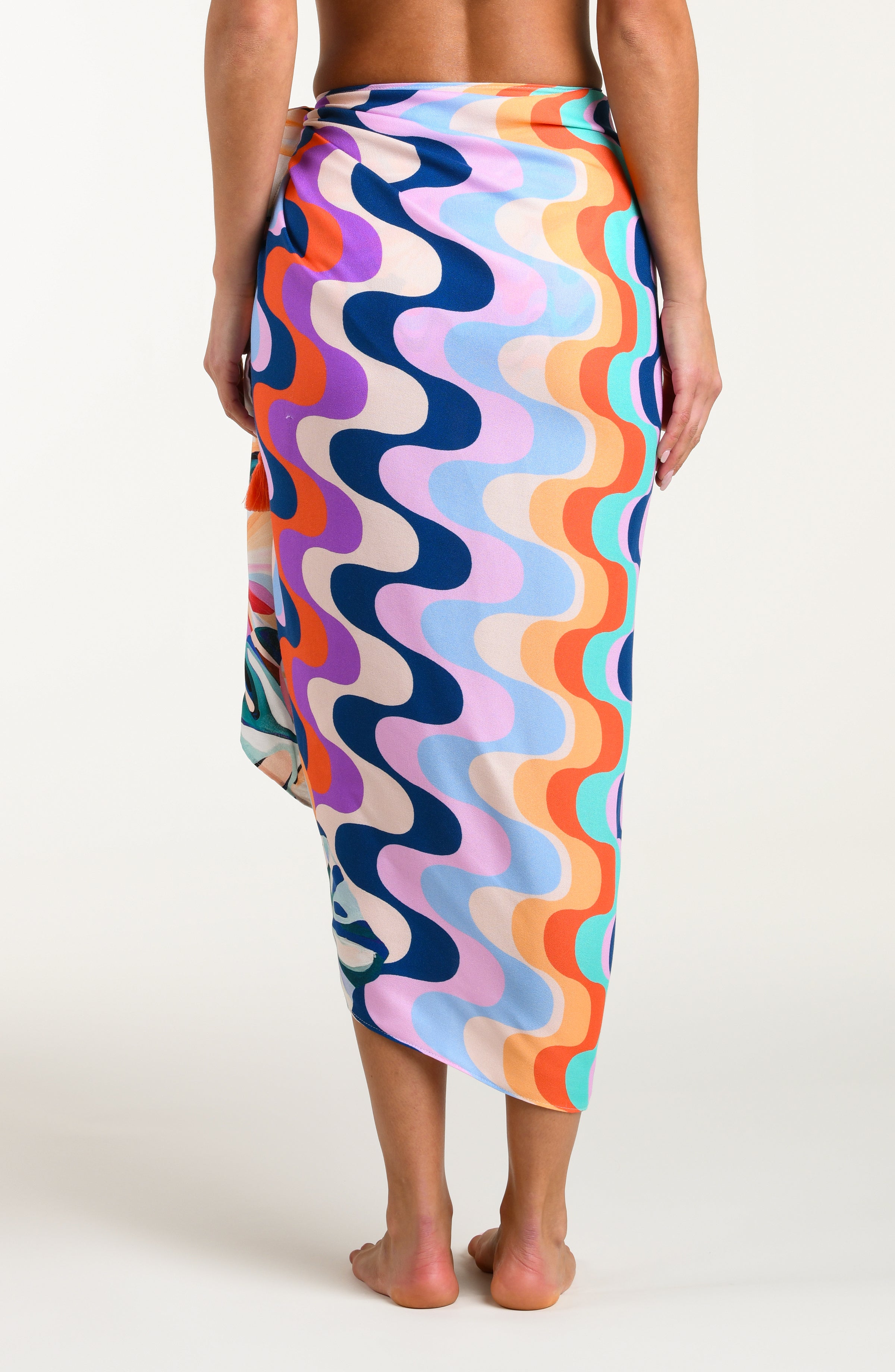 Multicolored patterned pareo wrap being worn by a person on a white background