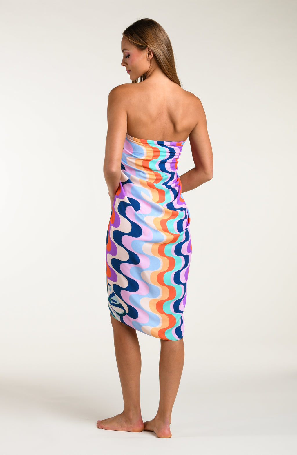 Woman wearing a multicolored patterned pareo wrap on a white background