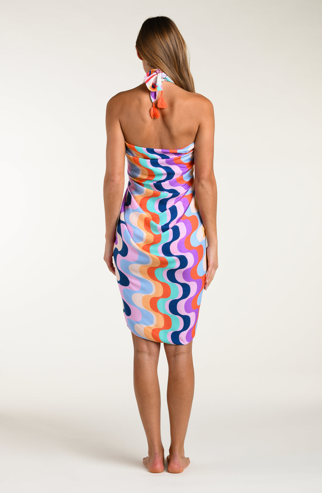 Woman wearing a multicolored patterned pareo wrap on a white background