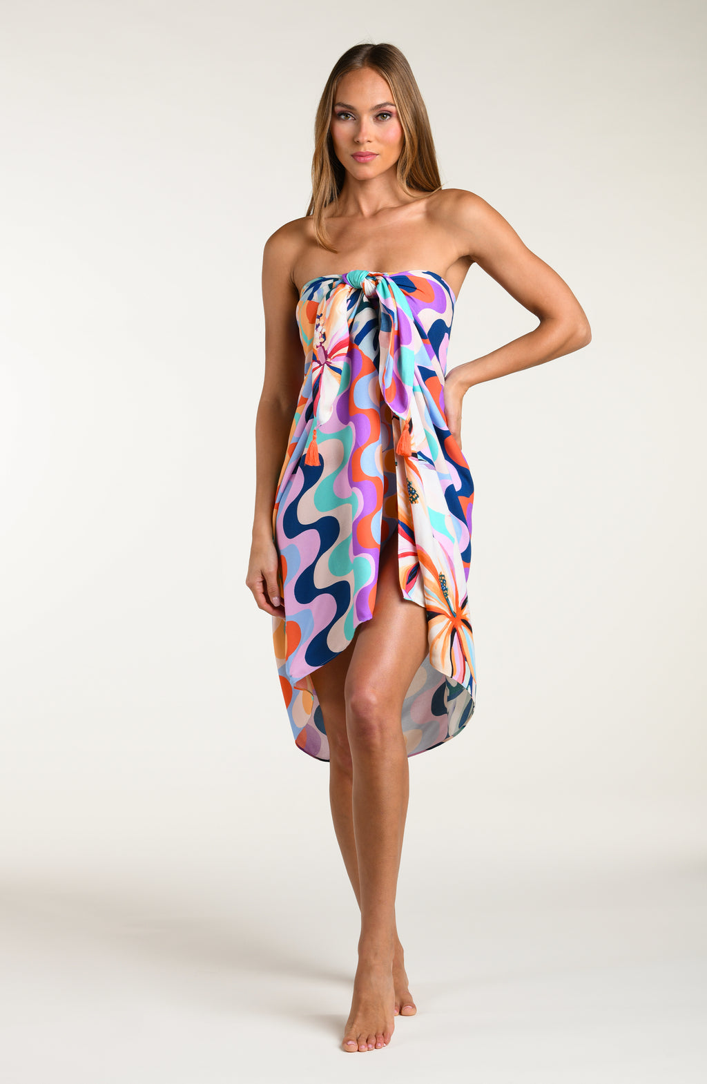Woman wearing a multicolored patterned pareo wrap on a white background