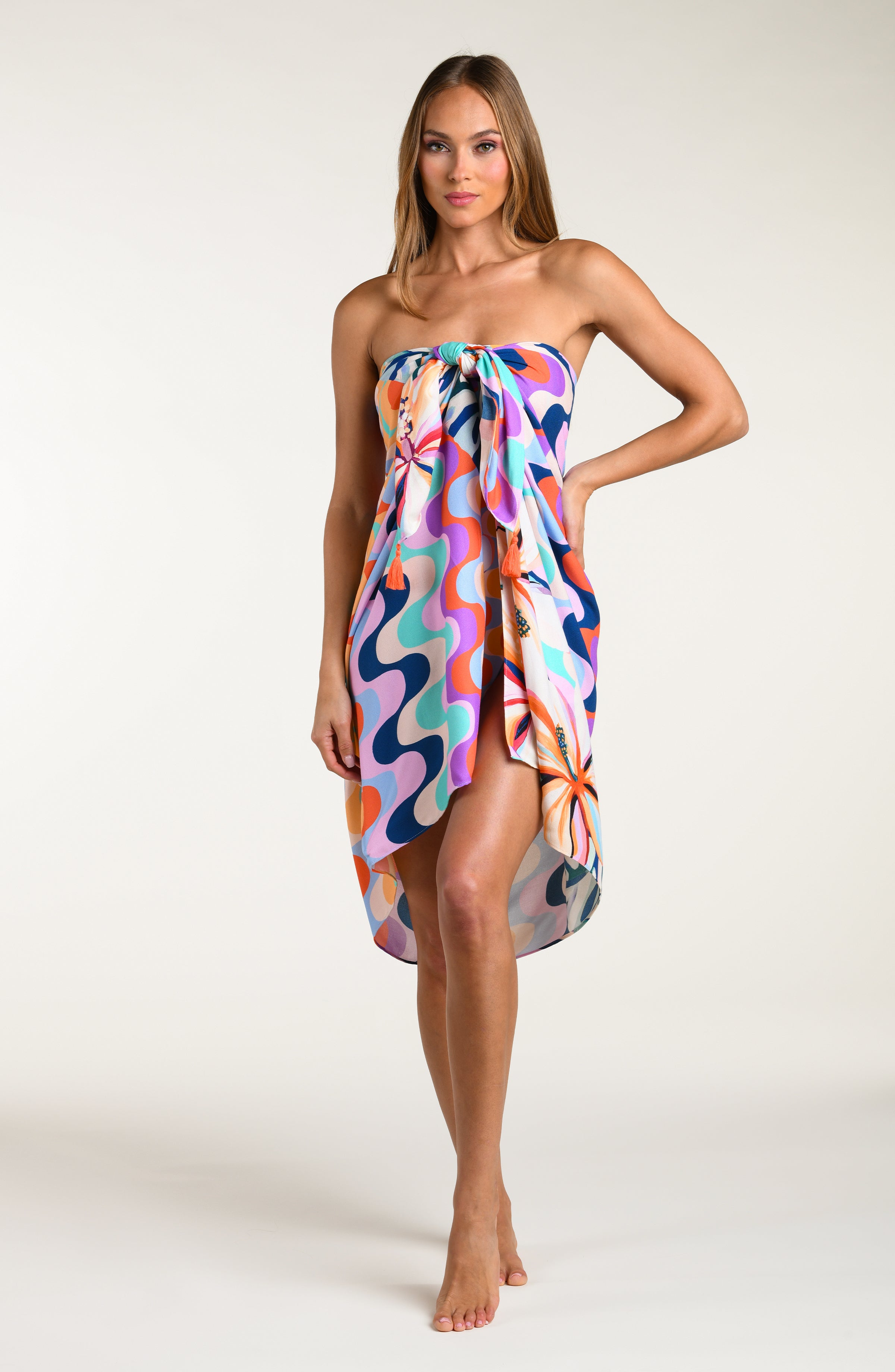 Woman wearing a multicolored patterned pareo wrap on a white background