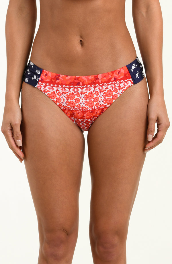 Red and white patterned bikini bottom on a plain background
