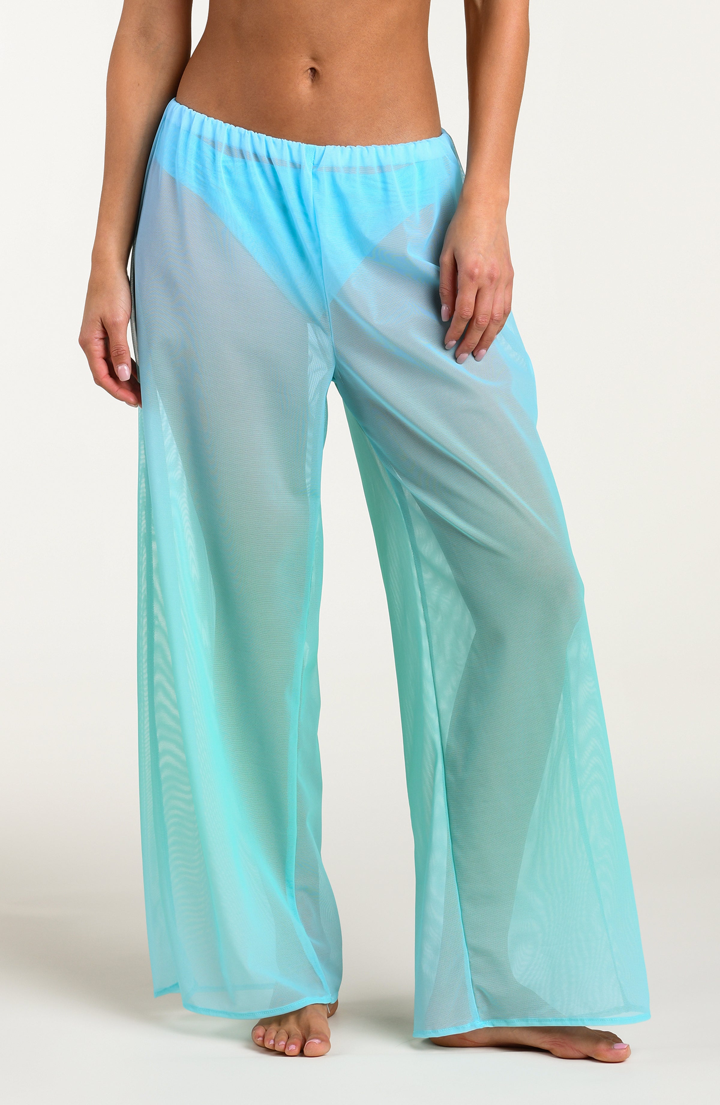 Turquoise colored sheer pants worn by a person against a white background