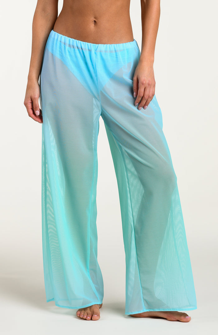 Turquoise colored sheer pants worn by a person against a white background