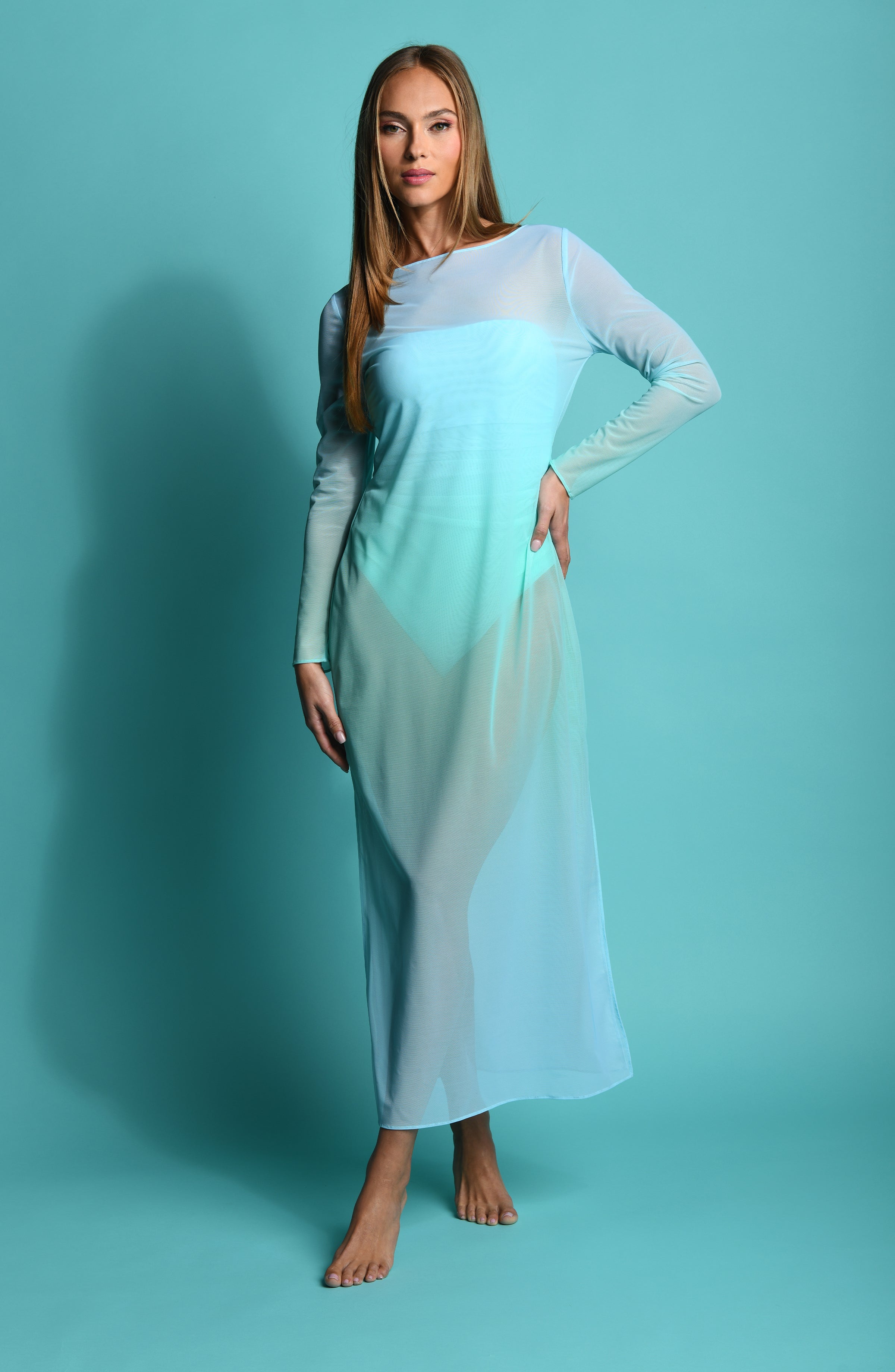 Woman wearing a light blue maxi dress with a gradient effect against a teal background