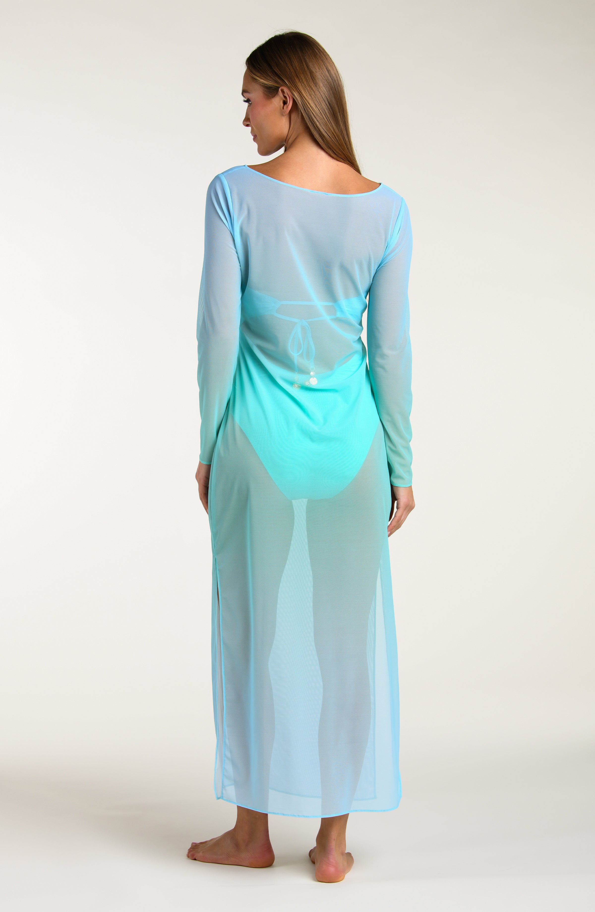 Woman wearing a long, turquoise maxi dress with a gradient effect against a white background