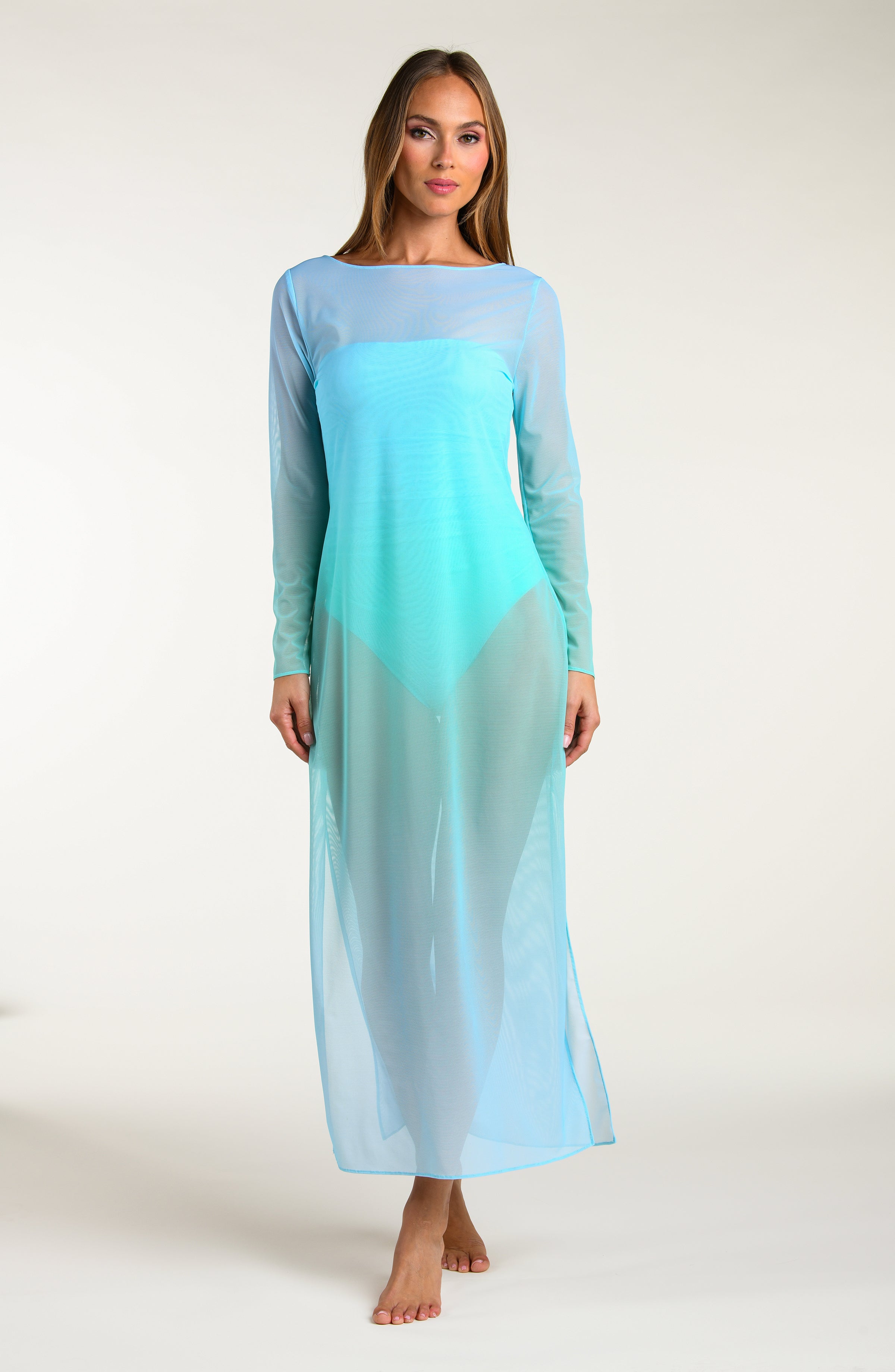Woman wearing a long, turquoise maxi dress with a gradient effect against a white background