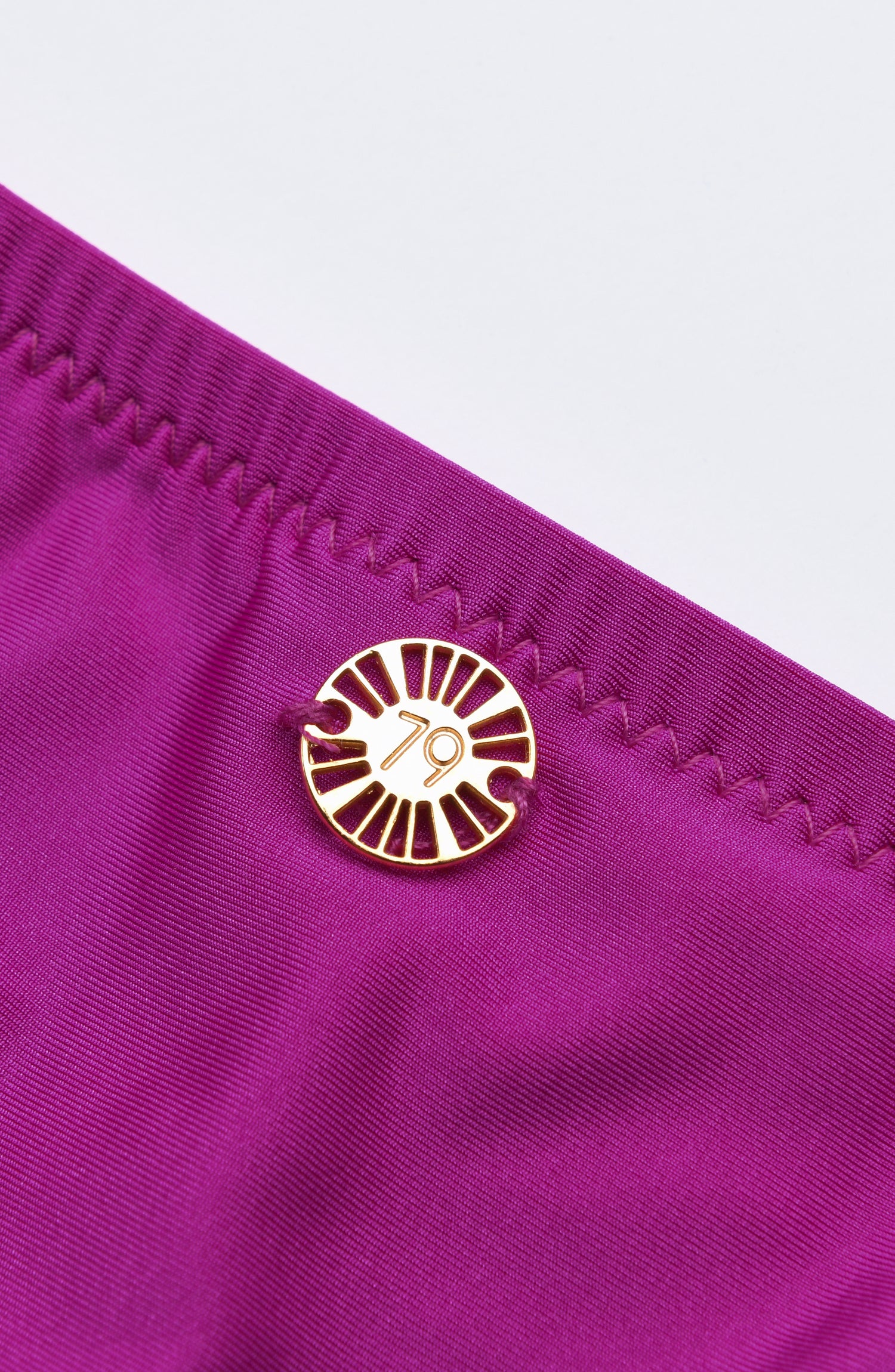 Detail image of Sunshine 79 charm on a Bright Violet swimsuit.