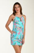 Woman wearing a colorful tropical print cover up dress on a white background