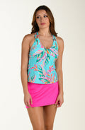 Woman wearing a colorful tankini top and pink swim skirt on a white background