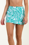 Teal and white patterned swim skirt worn by a person on a beige background