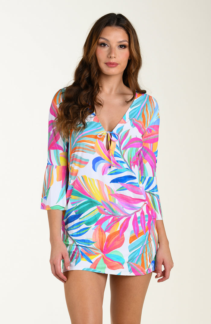 Front image of model wearing a multicolored (mostly pink) tropical printed cover-up dress featuring a relaxed, flowy fit with three-quarter sleeves, a tie-front neckline, and pockets.