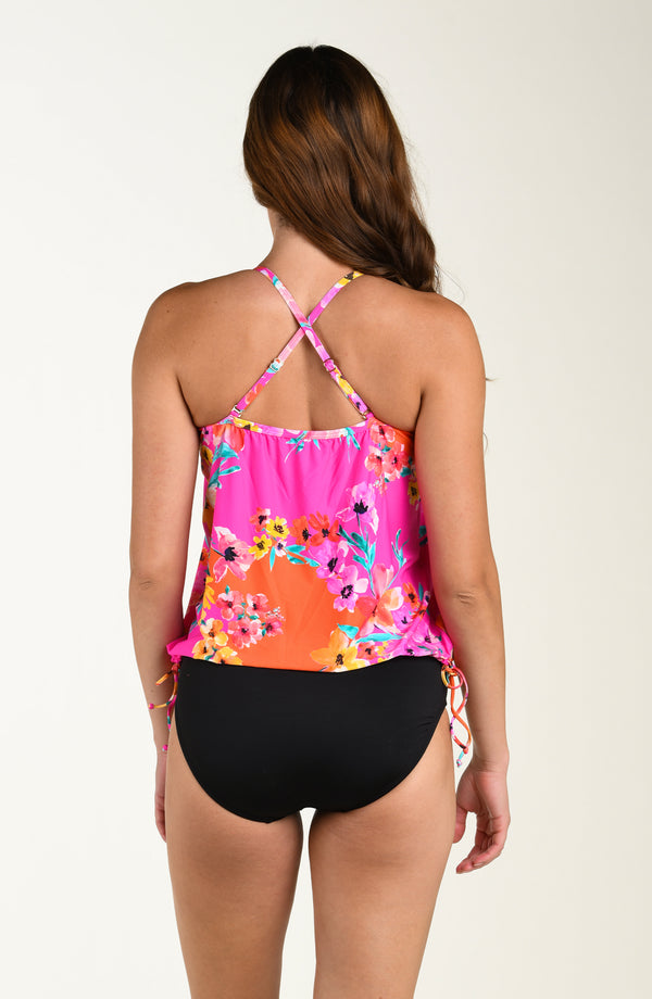 Back image of model wearing a multicolored pink floral printed tankini top featuring a relaxed, flowy fit with cross-back straps, straight back, and a drawstring hem for customizable style. This is paired with solid black colored bikini bottoms.