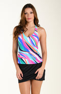 Woman wearing a colorful striped tankini top with a black swim skirt on a beige background