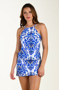 Woman wearing a blue and white patterned dress on a plain background