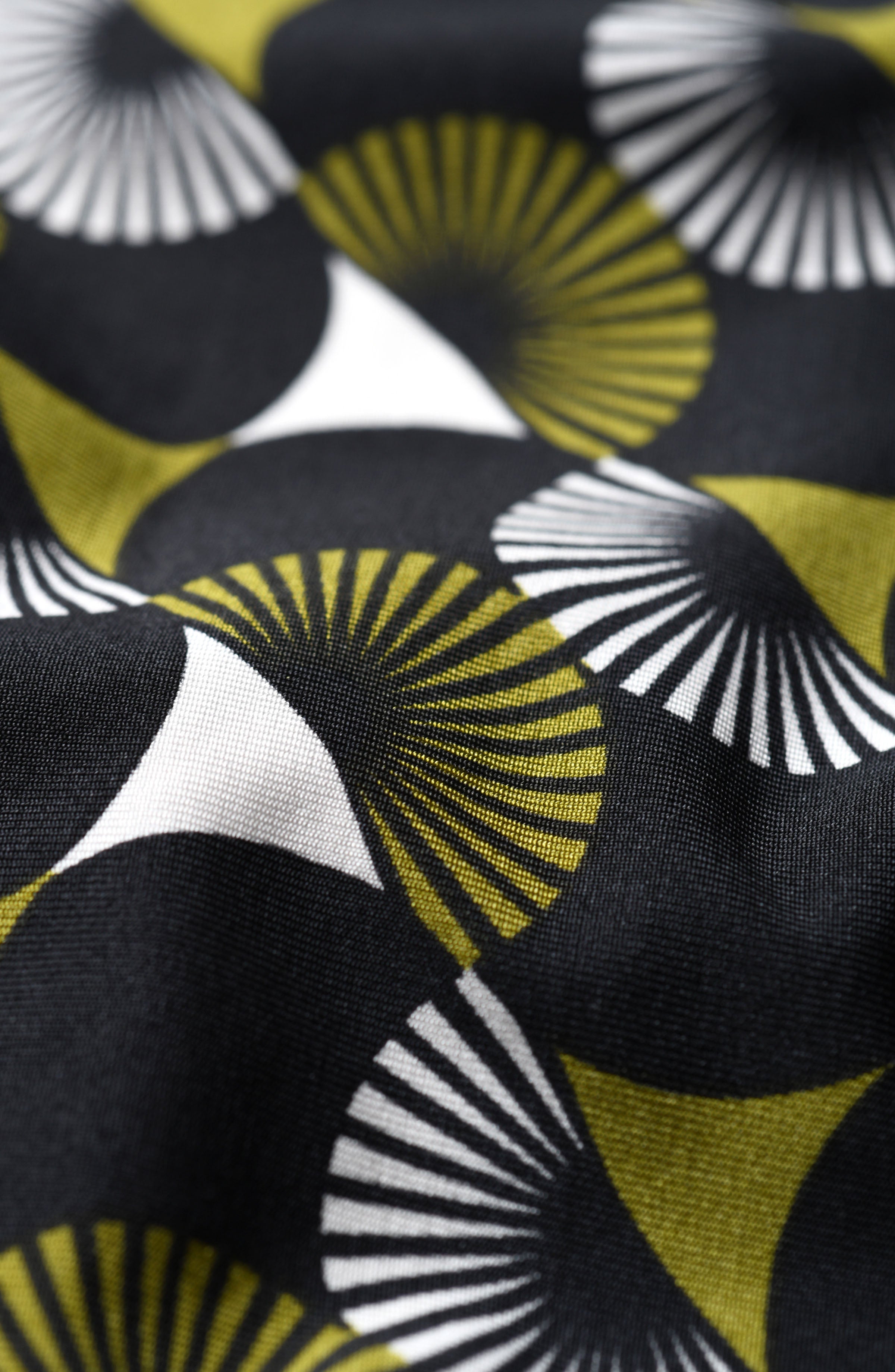 Close-up of fabric with geometric pattern featuring black, yellow, and white.
