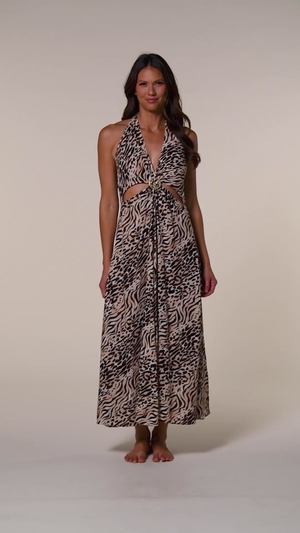Video of a woman wearing a zebra printed maxi dress cover up against a white background