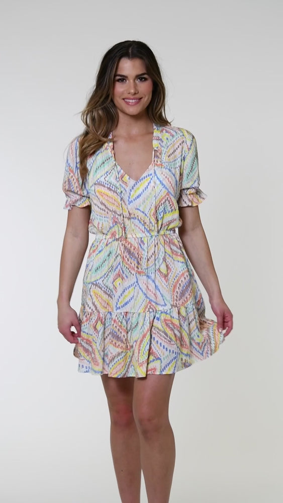 
            
                Load and play video in Gallery viewer, Model is wearing a geometric patterned cover-up dress in pastel shades of pink, blue, and yellow, accented with sporadic glimmers of gold sequin-like details on a white background.
            
        