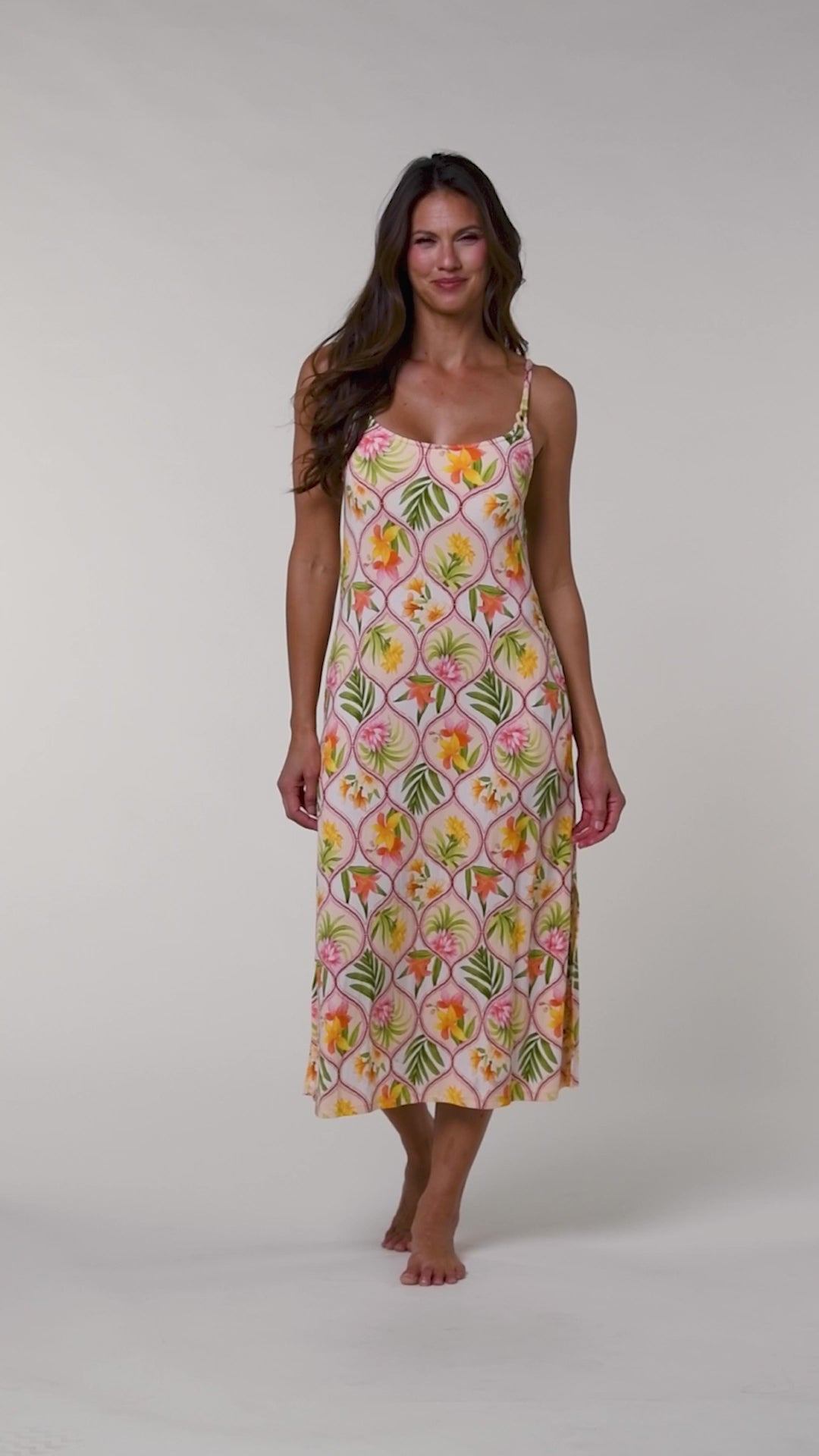 Video of a woman wearing a floral cover up dress on a white background