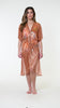 Model is wearing a shimmering orange and pink short sleeve midi dress cover up.