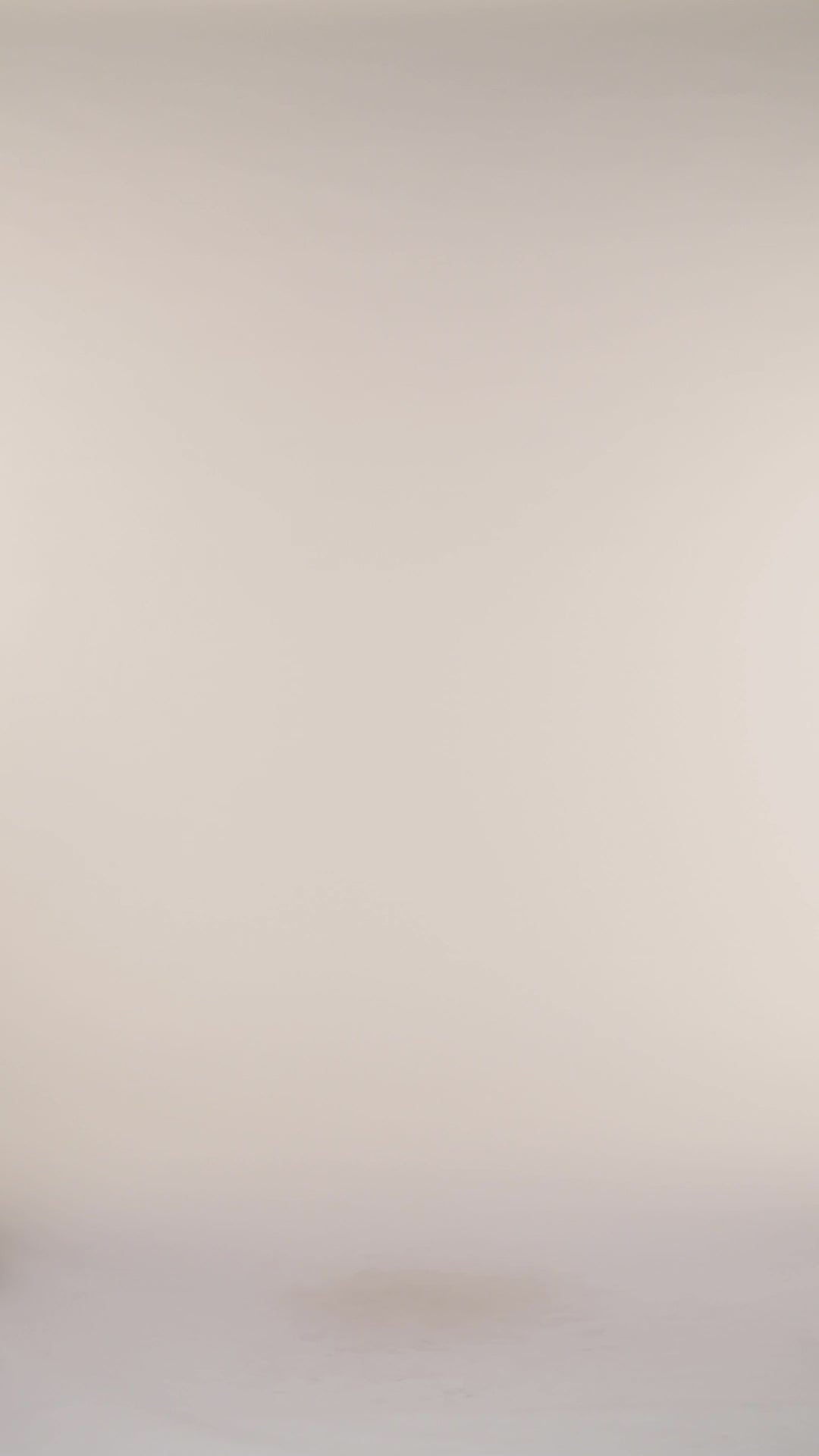 Video of model wearing a multicolored feather printed halter bikini top triangle cups and gold ring accents at the straps. This is paired with matching bikini bottoms and cover up.