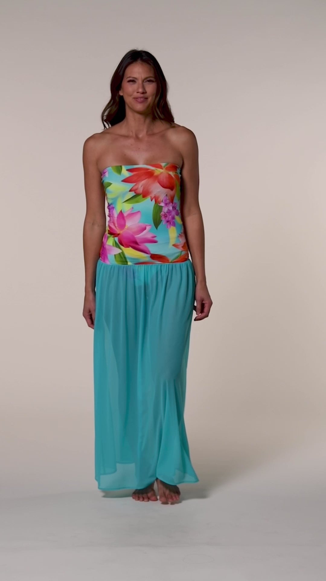 Video of a woman wearing a turquoise convertible maxi dress cover up against a white background