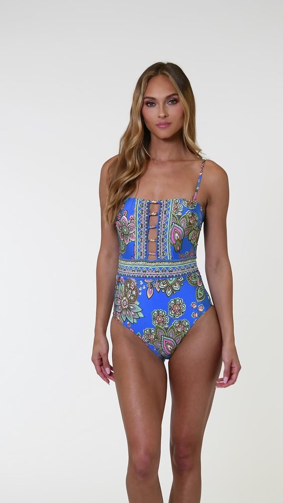 
                  
                    Load and play video in Gallery viewer, Model is wearing a pink, orange, teal, and green multicolored floral patterned bandeau one piece swimsuit set against an indigo blue background.
                  
                