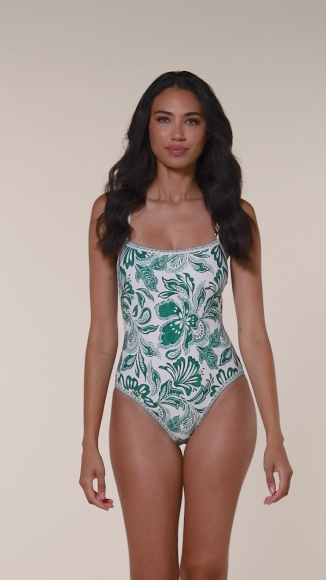 Video of a woman wearing a green floral one-piece swimsuit